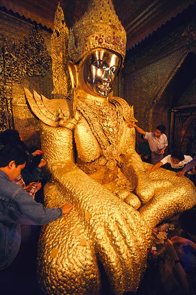 Pilgrims applying gold leaf to the Maha Muni Buddha Mandalay, Burma