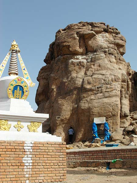 Shamanic sacred rock with pilgrim praying for ease in childbirth